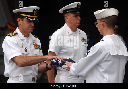 050629-N-5345W-052-Atlantik (29. Juni 2005) - Kommandierender Offizier, USS Harry S. Truman (CVN-75), Captain James P. Gigliotti, links, präsentiert ein gefaltetes Ensign während einer Beerdigung am Meer Zeremonie für Seaman 2. Klasse Jacob W. King, ein Veteran des zweiten Weltkrieges, die 28. August 2004 im Alter von 79 Jahren verstorben. Ur-Enkel des Königs, des Maschinisten Mate 1. Klasse James Van Dyke derzeit an Bord des Schiffes. Truman führt derzeit Träger Qualifikationen und Operationen von der Ostküste. US Navy Foto vom Fotografen der 3. Klasse Kristopher Wilson (freigegeben) Paaren uns Marine 050629-N-5345W-052 Stockfoto