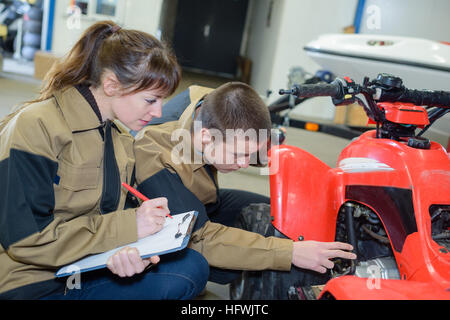 junge Mechaniker Prüfung quadbike Stockfoto