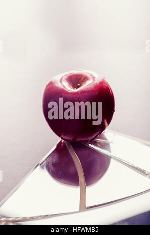 Roter Apfel auf rissige zerbrochenen Spiegel reflektieren Stockfoto