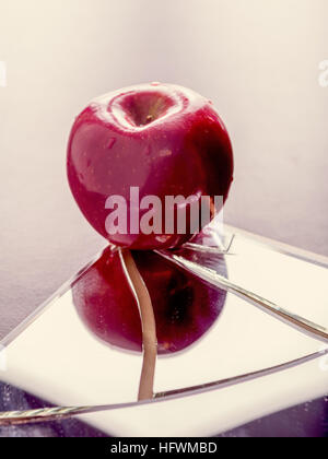 Roter Apfel auf rissige zerbrochenen Spiegel reflektieren Stockfoto