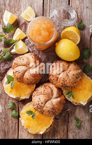 Süße Brötchen mit Marmelade und Butter Nahaufnahme Zitrone auf dem Tisch. vertikale Ansicht von oben Stockfoto