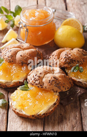 Süße Brötchen mit Marmelade Zitrone, Minze und Butter auf den Tisch-Nahaufnahme. vertikale Stockfoto