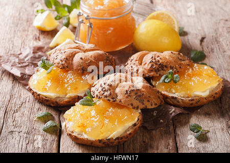 Süße Brötchen mit Marmelade Zitrone, Minze und Butter auf den Tisch-Nahaufnahme. Horizontale Stockfoto