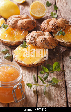 Süße Brötchen mit Marmelade Zitrone, Minze und Butter auf den Tisch-Nahaufnahme. vertikale Stockfoto