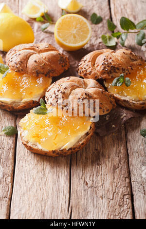 Süße Brötchen mit Marmelade und Butter Nahaufnahme Zitrone auf dem Tisch. vertikale Stockfoto