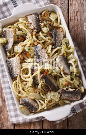 Spaghetti mit Sardinen, Fenchel, Rosinen, Nüssen und Petersilie hautnah in Auflaufform auf den Tisch. vertikale Ansicht von oben Stockfoto