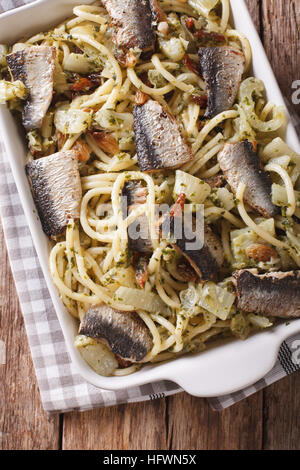 Bucatini italienische Pasta mit Sardinen, Fenchel, Rosinen und Pinienkernen hautnah in Auflaufform legen. vertikale Ansicht von oben Stockfoto