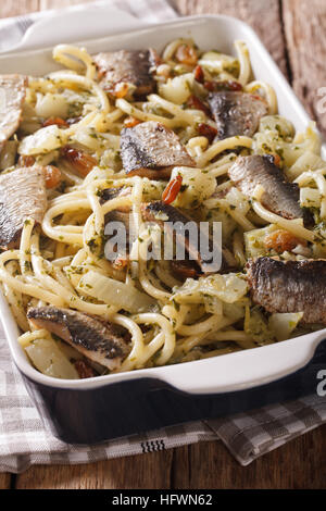 Pasta mit Sardinen, Fenchel, Rosinen und Pinienkernen und Petersilie hautnah in Auflaufform auf den Tisch. vertikale Stockfoto