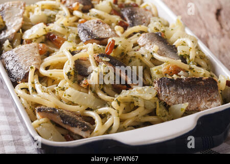 Bucatini italienische Pasta mit Sardinen, Fenchel, Rosinen und Pinienkernen hautnah in Auflaufform legen. horizontale Stockfoto