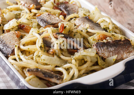 Italienische Pasta mit Sardinen, Fenchel, Rosinen und Pinienkernen Makro in eine Auflaufform legen. horizontale Stockfoto