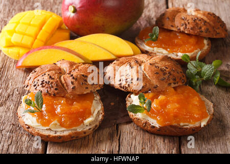 Süß, frisch gebackene Brötchen mit Mango Marmelade, Butter und Minze Nahaufnahme auf dem Tisch. horizontale Stockfoto