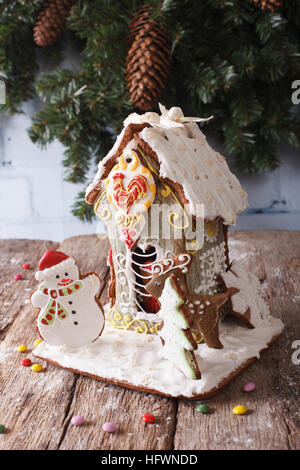 Weihnachten Lebkuchen Haus und Cookie Closeup auf dem Tisch vor dem Hintergrund des Weihnachtsbaumes. vertikale Stockfoto