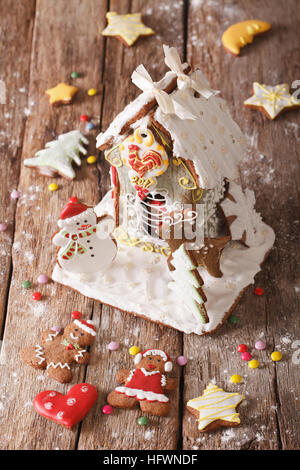 Weihnachten glasierten Lebkuchen Haus und Cookie close-up auf dem Tisch. vertikale Stockfoto