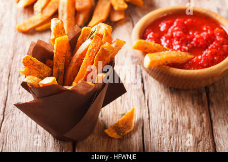 Süßkartoffel Pommes mit Rosmarin und Ketchup-close-up auf dem Tisch. Horizontal, rustikal Stockfoto