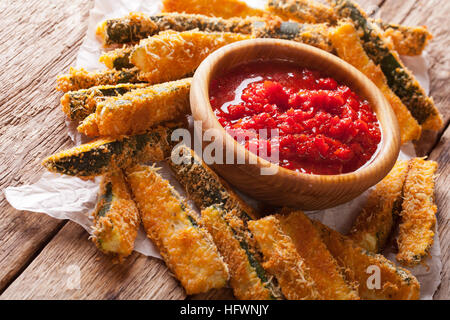 Gebackene Zucchinischeiben mit Parmesan und würzigen Tomaten Sauce Closeup auf einem Tisch. horizontale Stockfoto