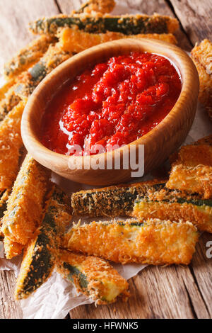 Gebratene Zucchini-Sticks in Panade und Tomaten Sauce Nahaufnahme auf einem Tisch. vertikale Stockfoto