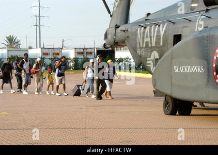 050903-N-1467R-005 New Orleans (3. September 2005) – US Marine Aviation Maschinist ist Mate 2. Klasse Kirk Crabb, der Hubschrauber Mine Gegenmaßnahmen Geschwader 15 (HM-15), "Black Hawks" zugewiesen, lenkt, dass Hurrikan Katrina Überlebende in die hintere Rampe eine MH-53E Sea Dragon am Parkplatz Ernest N. Morial Convention Center in New Orleans Hubschrauber. HM-15 führt Relief, dass Operationen aus dem amphibischen Angriff Schiff USS Bataan (LHD-5) in den Golf von Mexiko. Der Marine-Beteiligung an der Hurricane Katrina humanitäre Hilfseinsätze wird von der Federal Emergency Management Agen geführt. Stockfoto