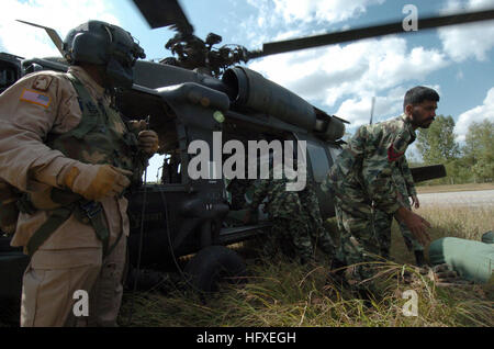 051012-N-8796S-071 Rawalakot, Pakistan (12. Oktober 2005) - überwacht ein US Army Aircrew Mitglied das Entladen von einem UH-60 Blackhawk Hubschrauber als Mitglieder von Pakistan militärische Stack Zelte und andere humanitäre Soforthilfe in der abgelegenen pakistanischen Dorf Rawalakot. Die Regierung der Vereinigten Staaten beteiligt sich an einer multinationalen humanitäre Hilfe und Unterstützung Aufwand führen durch die pakistanische Regierung um Hilfe für die Opfer des verheerenden Erdbebens zu bringen, die die Region 8. Oktober 2005 geschlagen. Foto: U.S. Navy PhotographerÕs Mate 2. Klasse Timothy Smith (freigegeben) US Navy 051012-N-8796S-071 A U.S. Ar Stockfoto