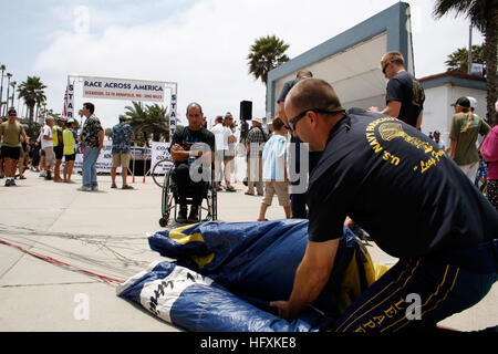 090617-N-7603L-108 OCEANSIDE, Kalifornien (17. Juni 2009) Jim Woods, ein ehemaliger Navy SEAL, die US Navy Fallschirm-Team, die Frösche springen zugewiesen spricht mit Zuschauer Carlos Moleda, wie er seinen Fallschirm nach einer Team-Fallschirm-Demonstration zum Start des Rennen in Amerika Marathon, ein 3.000 Meilen Radrennen packt. Die Frösche springen haben ihren Sitz in San Diego und führen an verschiedenen Standorten über das Land, das Navy Exzellenz zu präsentieren und das Bewusstsein über Naval Special Warfare. (Foto: U.S. Navy Mass Communication Specialist 3. Klasse John Lamb/freigegeben) US Navy 090617-N-7603L-108 Stockfoto