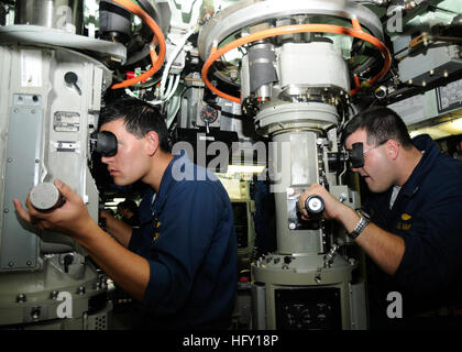 Offiziere scannen den Horizont durch Periskope an Bord des Angriffs-U-Bootes USS Santa Fe (SSN 763) während eines Pazifik-Transits, während sie auf Kontakte achten und die Navigationssicherheit aufrechterhalten. Stockfoto