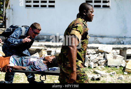 100129-N-7948C-087 KILLICK, Logistik-Spezialist für Haiti (29. Januar 2010) 3. Klasse Jerdone McGhee, links, aus Austin, Texas, spricht mit einem haitianischen Frau, die medizinisch evakuiert ist, da Lt. Amara Kallon, von der Sierra Leone-Marine hilft der trage zu einer Landezone am Killick haitianische Küstenwache tragen. Beide Segler sind für Afrika Partnerschaft Station West an Bord der amphibischen Dock Landungsschiff USS Gunston Hall (LSD 44) begann das internationale Personal zugewiesen. Gunston Hall unterstützt einheitliche Antwort auf einen Vorgang nach einem Erdbeben der Stärke 7,0, die schwere Schäden Stockfoto