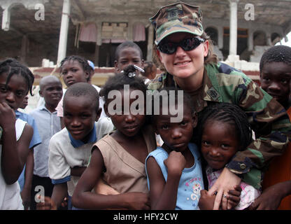 100218-M-8605C-005 CARREFOUR, Haiti (18. Februar 2010) Chief Petty Officer Charlotte Reijo zugewiesen, der Navy Maritime zivilen Angelegenheiten Team (MCAT) 207, begann auf dem Mehrzweck amphibischer Angriff Schiff USS Bataan (LHD-5), trifft sich mit Kindern von Carrefour, Haiti. Die Maritime Civil Affairs Team engagiert sich mit lokalen haitianische Organisationen Vertriebenen Haitianer Unterstützung gewähren. (Foto: U.S. Marine Corps CPL Bobbie A. Curtis/freigegeben) UNS Marine 100218-M-8605C-005 Chief Petty Officer Charlotte Reijo, zugeordnet der Navy Maritime Civil Affairs Team (MCAT) 207 trifft mit Kindern aus Stockfoto