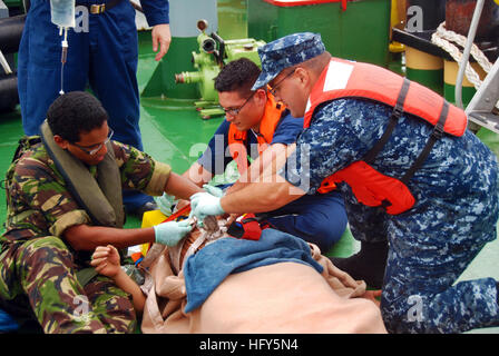 100422-N-1401J-115 indischen Ozean (22. April 2010) Royal Navy führende medizinische Assistenten Richard Bastianpulle, links, Hospital Corpsman 3. Klasse Adam Delatorre und kulinarische Spezialist 1. Klasse Matthew West, alle drei zugewiesenen Befehle auf Diego Garcia, geben erste Hilfe, ein verletzter Seemann an Bord eines fremden Schiffes. Später wurde der Segler nach Branch Health Clinic, Diego Garcia zur Weiterbehandlung geschickt. (Foto: U.S. Navy Masse Kommunikation Spezialist Christopher S. Johnson/freigegeben) US Navy 100422-N-1401J-115 medizinische geben erste Hilfe, ein verletzter Seemann an Bord ein fremdes Schiff Stockfoto