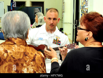 100603-N-3620L-067 TALOFOFO, Guam (3. Juni 2010) Lt. CMdR Mike Foskett, Kaplan zugewiesen, die amphibische Transportschiff der Dock USS Dubuque (LPD 8), spielt die Ukulele wie Einheimische ältere Frauen während einem ehrenamtlichen Projekt im Yona/Talofofo Senioren Center in Talofofo das Chamorro-Lied singen. Mehr als ein Dutzend Matrosen und Marinesoldaten aus Dubuque und der 15. Marine Expeditionary Unit (MEU 15.) nahmen an der Veranstaltung. (Foto: U.S. Navy Mass Communication Specialist 2. Klasse Peter Lewis) US Navy Lt. CMdR Mike Foskett spielt die Ukulele, wie ältere Frauen die Chamorro-s singen Stockfoto