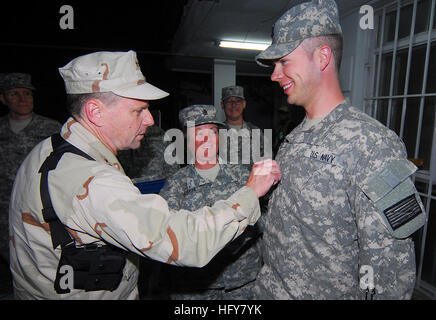 Kabul, Afghanistan - Vice Admiral Bill Gortney, links, Commander, US Marine Forces Central Command/5th Flotte, Reißzwecken "Crow" auf Petty Officer 1st Class Christopher Parks als Chief Petty Officer Delisa Sliker, seinem Sponsor Uhren während einer frocking Zeremonie am Camp Eggers. Während seines Besuchs in Camp Eggers amtierte das Hauptquartier der NATO Training Mission - Afghanistan, Gortney traf sich mit Kommandostab, bei einer frocking Zeremonie für sechs Segler und sprach offen mit Matrosen über die Bedeutung ihrer Mission in Afghanistan. (U.S. Navy Photo by Chief Masse Kommunikation Spezialist F. Julian Carroll) VERÖFFENTLICHUNG Stockfoto