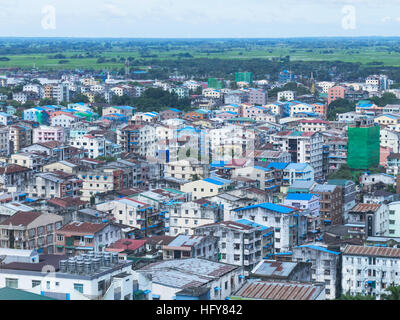 Wohngebiet in der Innenstadt von Yangon, die Hauptstadt von Myanmar, mit Reisfeldern im Hintergrund Stockfoto