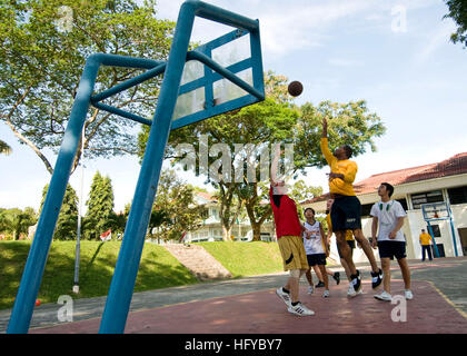 Während einem ehrenamtlichen Projekt schießt Seemann Sonny Turner von Lakeland, Florida, eine Layup bei einem Basketball-Spiel mit dem Personal und der Jugend der jungen Stadt Singapur. Segler aus dem Flugzeugträger USS George Washington und Carrier Air Wing 5 Sport und teilten uns eine Mahlzeit mit Kinder und Mitarbeiter von jungen Stadt Singapur. George Washington, kam mit seiner kombinierten Besatzung von mehr als 5.000 Matrosen in Singapur Aug. 11, so dass es die zweite Freiheit Anlaufhafen seit Yokosuka, Japan für das Schiff 2010 Sommer Patrouille herausziehen. (US Navy Foto/Petty Officer 3rd Class Danielle Brandt) USS Stockfoto