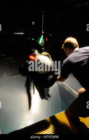 101013-N-5787K-056 (13. Oktober 2010) NORFOLK Navy Diver 1. Klasse Robert Johnson, Dozent an der Luftfahrt-überleben-Schulung wirft ein Student auf einer Hebebühne steht während der Nacht Sturm-Übung, die Worst-Case-Szenarien in der Nacht simuliert. Dieser zweitägige Kurs ist obligatorisch alle vier Jahre für alle, die in der US Navy und des Marine Corps Flugzeug fliegt. (Foto: U.S. Navy Mass Communication Specialist 2. Klasse Meranda Keller/freigegeben) US Navy 101013-N-K 5787-056 Navy Diver 1. Klasse Robert Johnson, Dozent an der Luftfahrt-überleben-Schulung stellt sich ein Student auf eine Hois Stockfoto