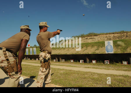 101028-N-4936C-240 GUANTANAMO BAY, Kuba (28. Oktober 2010) Luftfahrt Kriegsführung Systeme Operator Chief Eddie Gomez feuert eine 9 mm Pistole als Firing Line Coach Waffenwart 1. Klasse Errol Cummings blickt auf. Gomez und Cummings sind beide zu Marine Expeditionary Guard Battalion (NEGB) zugeordnet. NEGB bietet einen Teil der Wache Kraft innerhalb der Joint Task Force Guantanamo Haftanstalten. (Foto: U.S. Navy Mass Communication Specialist 1. Klasse David P. Coleman/freigegeben) US Navy 101028-N-4936C-240 Aviation Kriegsführung Systeme Operator Chief Eddie Gomez Brände eine 9 mm Pistole als Schusslinie coach Master- Stockfoto