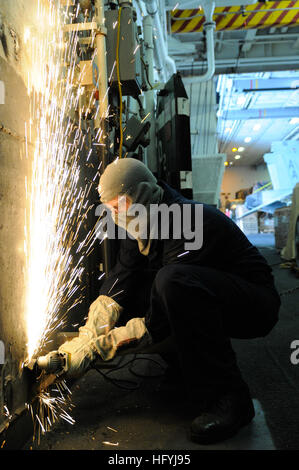 101220-N-8040H-059 Pazifik (20. Dezember 2010) Rumpf Wartung Techniker Feuerwehrmann Lehrling Anthony Fleeman schleift vor Gefahren für die Sicherheit im Hangar Bucht an Bord des Flugzeugträgers USS Carl Vinson (CVN-70). Carl Vinson und Carrier Air Wing (CVW) 17 sind auf einer dreiwöchigen zusammengesetzte Einheit Übung gefolgt von einer Bereitstellung in die USA 7. und USA 5. Flotte Aufgabenbereiche. (Foto: U.S. Navy Masse Kommunikation Spezialist Seemann Christopher K. Hwang/freigegeben) US Navy 101220-N-8040H-059 Rumpf Wartung Techniker Feuerwehrmann Lehrling Anthony Fleeman schleift sich Gefahren für die Sicherheit Stockfoto