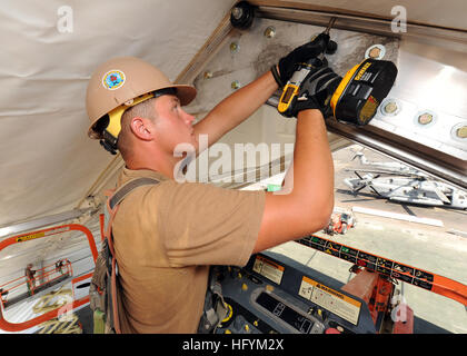 110225-N-SN160-084 CAMP LEMONIER, Dschibuti (25. Februar 2011) Equipment Operator Constructionman Dylan Uhls, zugeordnet zu am Detail Horn von Afrika (det HOA) der Naval Mobile Bau Bataillon (NMCB) 74, strafft Schrauben auf einem 110-Fuß von 130 Fuß gespannt Stoff Flugzeughangar. NMCB-74 det HOA unterstützt durch Partner Nation Kapazitätsaufbau und Förderung der regionalen Stabilität durch bautechnische Unterstützung gemäß der US-NavyÕs-Meeresstrategie kombiniert Joint Task Force-Horn von Afrika. (Foto: U.S. Navy Mass Communication Specialist 2. Klasse Michael Lindsey/freigegeben) UNS Stockfoto