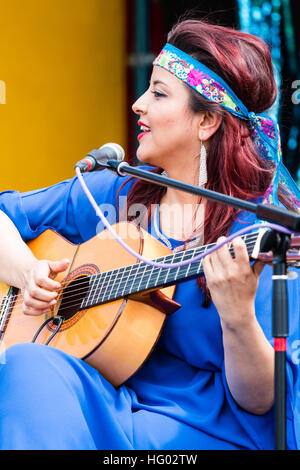 Kolumbianische Songwriter, Sänger und Gitarrist, Carolina Herrera in blauem Kleid, Gitarre spielen und Singen, während auf einer Open Air Bühne in Ramsgate. Stockfoto