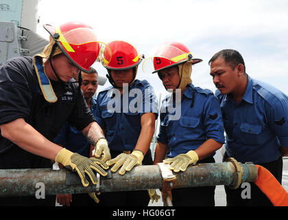 111003-N-ED900-262 MUARA, Brunei (3. Oktober 2011) Schaden Controlman 1. Klasse Aaron Hoke Praktiken Rohr Patchen mit Royal Brunei Navy Matrosen während der Schadensbegrenzung Ausbildung an Bord der Arleigh-Burke-Klasse geführte Flugkörper Zerstörers USS Dewey (DDG-105) im Rahmen der Zusammenarbeit über Wasser Reife und Ausbildung (CARAT) Brunei 2011. Karat ist eine Reihe von bilateralen Übungen jährlich in Südost-Asien, Beziehungen zu stärken und um Kraft Bereitschaft zu verbessern. (Foto: U.S. Navy Mass Communication Specialist 2. Klasse Eddie Harrison/freigegeben) US Navy 111003-N-ED900-262 Schaden Controlman 1. Klasse Aaro Stockfoto