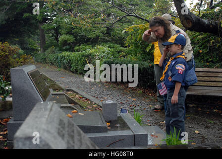 111111-N-MU720-019 YOKOHAMA, Japan (11. November 2011) A Scout und seine Mutter aus Boy Scouts Truppe 35 Yokosuka, Rendern Ehrungen nach dem Platzieren einer amerikanischen Flagge auf die Grabstätte eines gefallenen Dienst-Mitglieds auf dem Yokohama Foreign General Cemetery. Die Scouts geehrt die letzte Ruhestätte des US-Matrosen und Marinesoldaten, die in Japan gestorben und ihre Ehre am Grab von John Thomas Griffin, ein Pionier für die Pfadfinder in Japan. (Foto: U.S. Navy Mass Communication Specialist 2. Klasse Devon Dow/freigegeben) US Navy 111111-N-MU720-019 A Scout und seine Mutter aus Boy Scouts Truppe 35 Yokosuk Stockfoto