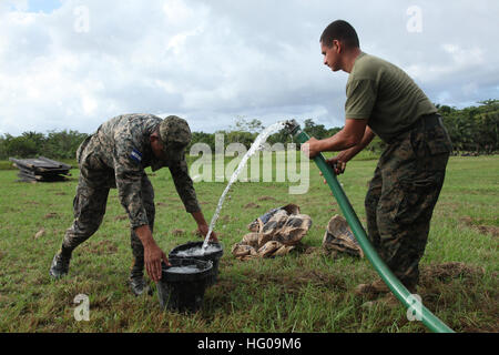 111124-M-IC831-153 PUERTO CASTILLO, Honduras (24. November 2011) Lance Cpl. Jose Ortiz, ein Kampfingenieur zugewiesen, der besondere Zweck Marine Air Ground Task Force (SPMAGTF), füllt Eimer mit Wasser für eine honduranische Service-Mitglied, Zement für einen Schießstand in Puerto Castillo zu mischen. Die Marines unterstützen Amphibious südlichen Partnerschaft Station 2012, einer jährlichen Bereitstellung von US Marine Vermögenswerte in den US Southern Command Verantwortungsbereich. (Foto: U.S. Marine Corps CPL Josh Pettway/freigegeben) UNS Marine 111124-M-IC831-153 Lance Cpl. Jose Ortiz, ein Kampfingenieur zugewiesen, das spezielle Pur Stockfoto