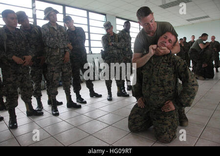 111128-M-IC831-020 PUERTO CASTILLO, Honduras (28. November 2011) US Marine Staff Sgt Joel Billingsley, eine Militärpolizei-Zug-Sergeant, veranschaulicht, wie Druck auf einen Druckpunkt unter dem Kinn von Lance Cpl. Steven Marshall anwenden. Die Marines werden zu besonderen Zweck Marine Air Ground Task Force (SPMAGTF), zugewiesen, die Amphibious südlichen Partnerschaft Station 2012, einer jährlichen Bereitstellung von US Marine Vermögenswerte in den US Southern Command Verantwortungsbereich unterstützt. (Foto: U.S. Marine Corps CPL Josh Pettway/freigegeben) US Navy 111128-M-IC831-020. S. Marine Staff Sgt Joel Billingsle Stockfoto