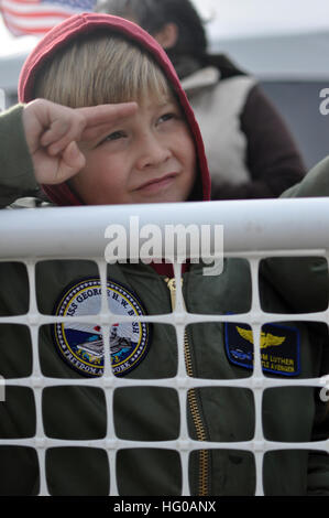 111210-N-FU443-672 NORFOLK (10. Dezember 2011) Tom Luther, Sohn von USS George H.W. Bush (CVN-77) Capt. Commanding Officer Brian Luther, grüßt das Schiff, wie es in der Naval Station Norfolk zieht. George H.W. Bush absolvierte seinen ersten Kampfeinsatz zur Unterstützung der Operationen Enduring Freedom und New Dawn. (Foto: U.S. Navy Mass Communication Specialist 2. Klasse Timothy Walter/freigegeben) US Navy 111210-N-FU443-672 A Segler Sohn begrüßt das Schiff, wie es in der Naval Station Norfolk zieht Stockfoto