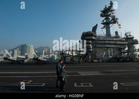 Matrosen transit das Flugdeck als der Flugzeugträger der Nimitz-Klasse, die USS Carl Vinson in Hongkong ankommt. Die Carl Vinson Strike Group ist in Hong Kong für einen Port-Besuch. USS Carl Vinson Aktion 111226-N-DR144-097 Stockfoto