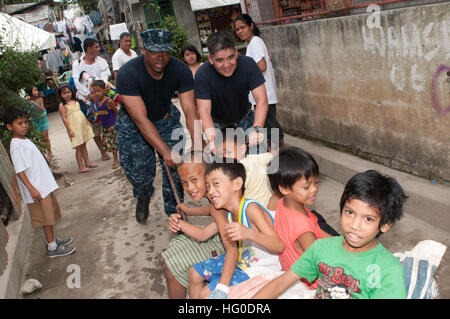 120201-N-OH194-080 MANILA, Philippinen (1. Februar 2012) Feuer Controlman 2. Klasse Kwasi Smith und Chief Hospital Corpsman Jason Juarez, zugeordnet der geführte Flugkörper-Zerstörer USS Wayne E. Meyer (DDG-108), spielen mit Kindern bei einem ehrenamtlichen Projekt in das Dorf Batasan Hills befindet sich im Abschnitt Quezon Stadt von Manila. Wayne E. Meyer, ein Mitglied der John C. Stennis Carrier Strike Group, in den USA bereitgestellt wird 7. Flotte Bereich der Verantwortung, die Sicherheit im Seeverkehr Operationen durchführen. (Foto: U.S. Navy Mass Communication Specialist 1. Klasse Grant P. Ammon/freigegeben) US Navy 12 Stockfoto