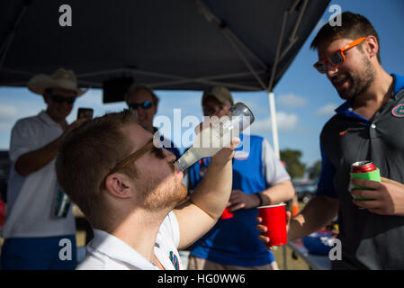 Florida, USA. 2. Januar 2017. LOREN ELLIOTT | Zeiten. Davis Beasley tuckert ein Smirnoff Ice, wie Casey Kracht (rechts) auf ihn vor dem Outback Bowl zwischen den Florida Gators und Iowa Hawkeyes im Raymond James Stadium in Tampa, Florida, auf Montag, 2. Januar 2017 jubelt. Beasley und Kracht sind Absolventen der Universität von Florida, und kam heraus, um mit Gleichgesinnten Gator Heckklappe. © Loren Elliott/Tampa Bay Times / ZUMA Draht/Alamy Live News Stockfoto