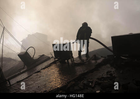 Dhaka, Bangladesch. 3. Januar 2017. Ein Feuerwehrmann arbeitet an einem Feuer in einem einen brennenden Shop auf einem Markt in Gulshan. Teil einer zweistöckigen DCC Markt zusammengebrochen wie ein massives Feuer auf dem Markt in Gulshan brach. © Monirul Alam/ZUMA Draht/Alamy Live-Nachrichten Stockfoto