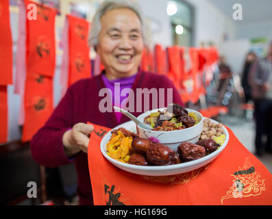 (170104)--HOHHOT, 4. Januar 2017 (Xinhua)--eine alte Frau zeigt die Inhaltsstoffe von Laba Congee in Hohhot, Hauptstadt von Nord-China autonomen Region Innere Mongolei, 4. Januar 2017. Das Laba Festival, ein traditionelle chinesische Urlaub am achten Tag des 12. Mondmonats fällt am 5. Januar dieses Jahres. Es ist üblich, an diesem Tag eine spezielle Laba Congee oder acht Schatz Brei, in der Regel aus mindestens acht Zutaten zubereitet, repräsentieren die Gebete Volkes für Ernte, Glück und Frieden zu essen. (Xinhua/Ding Genhou) (Angeles) Stockfoto