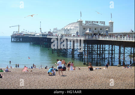 Menschen am Strand vor Brighton Pier. Stockfoto