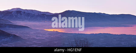 Die nebligen Wintermorgen in Kastoria, spiegelt der See Orestiada lila Himmel, Griechenland. Stockfoto