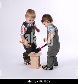 zwei kleine Jungs Reparatur Stuhl auf weiß Stockfoto