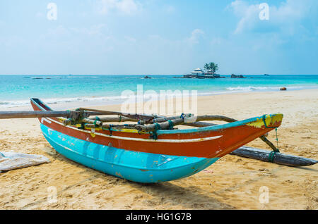 Die alten Katamaran Boot am Strand neben der Insel von Seenigama Muhudu Viharaya buddhistische Tempel, Hikkaduwa, Sri Lanka. Stockfoto